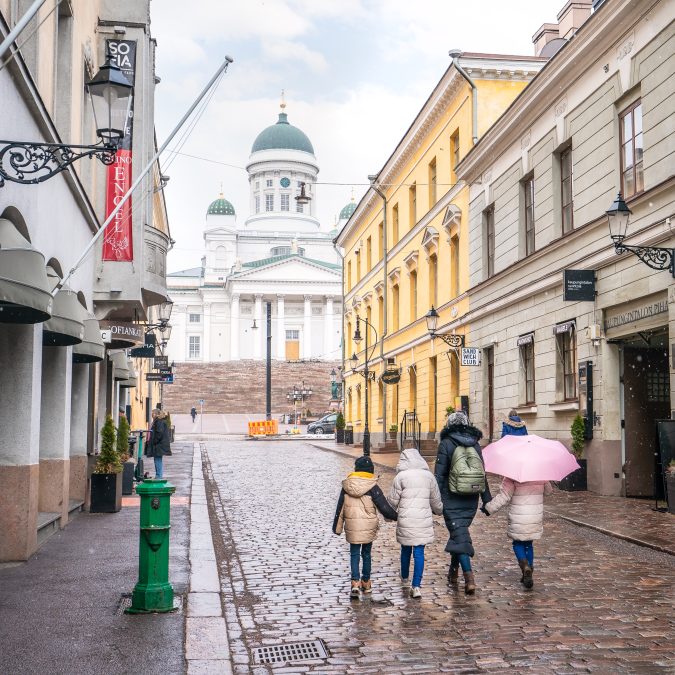 A woman and three children walking holding hands toward Helsinki Cathedral